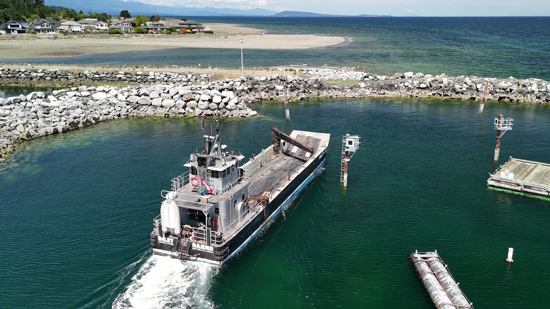 Aerial of the Inlet Raider running calm water inside a harbour breakwater