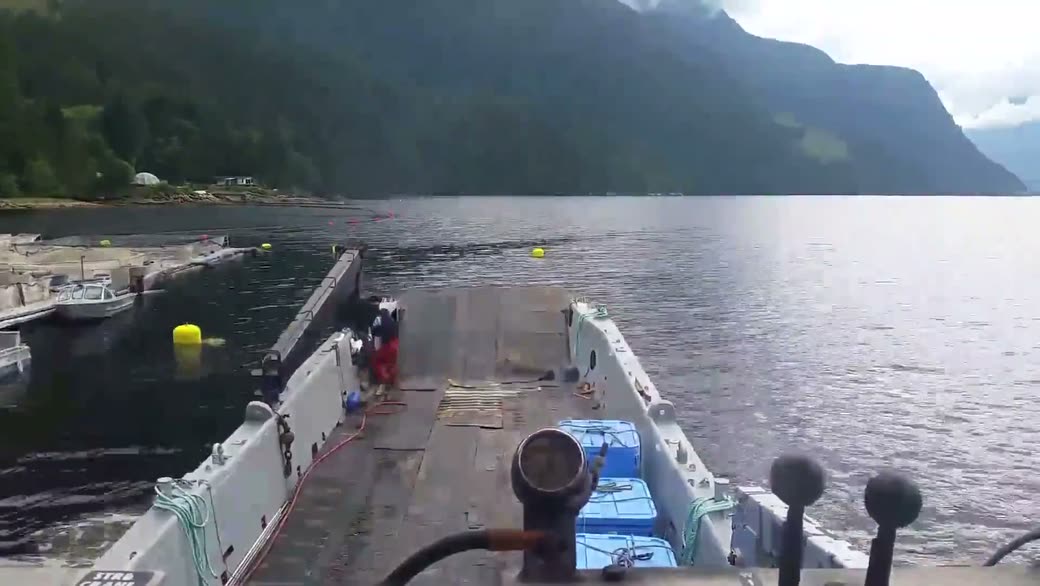 Blue totes on the deck as the boat comes in beside floats and buoys in an inlet