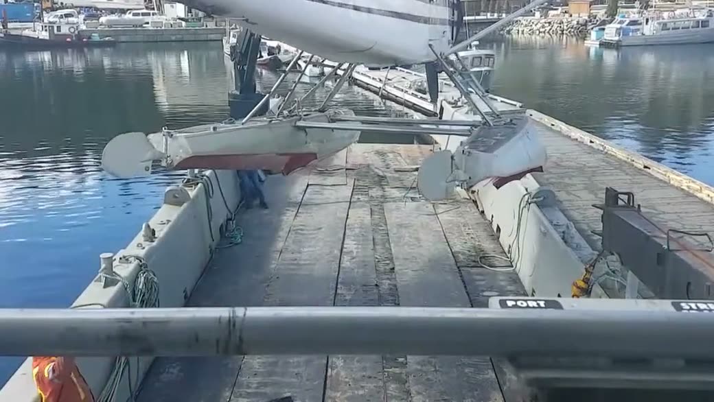 A floatplane lifted over the deck in a harbour